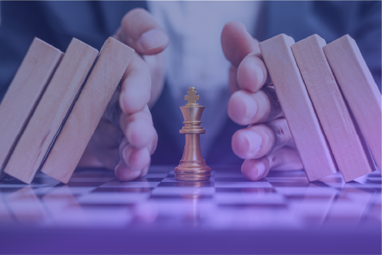 A golden king chess piece stands at the center of a chessboard, shielded by a pair of hands stopping a row of falling wooden dominoes. This image represents cybersecurity defense, risk mitigation, data protection strategies, and business security solutions against cyber threats.
